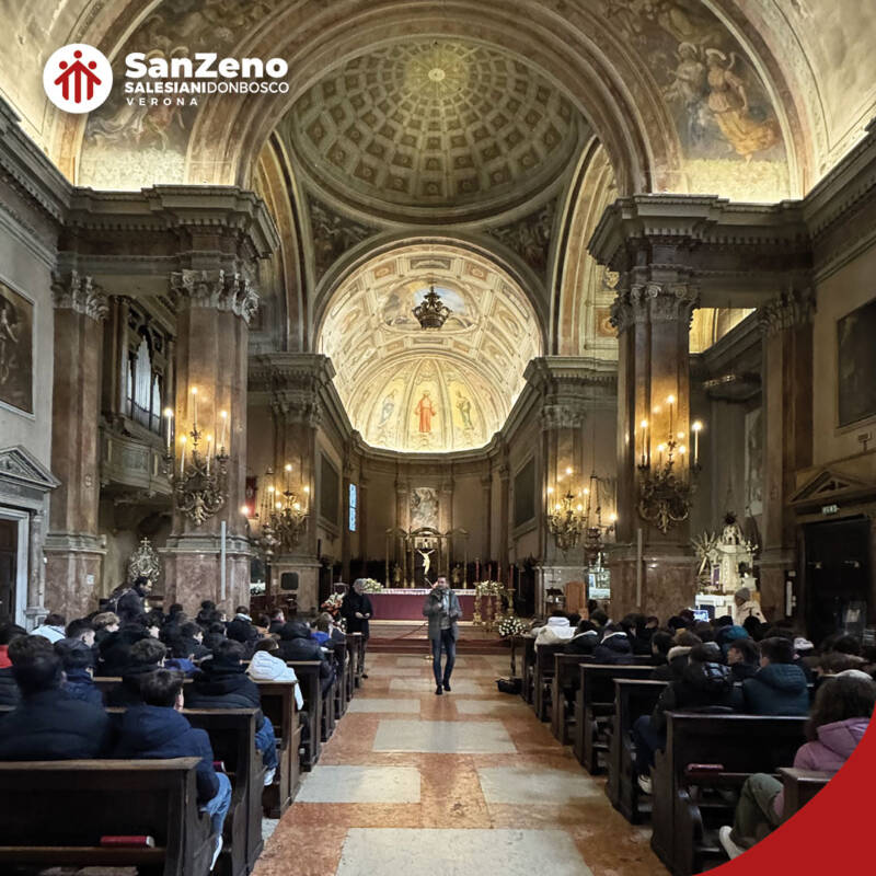 Un gruppo numeroso di persone è seduto sui banchi di una chiesa. Si tratta di studenti e studentesse dell'Istituto Salesiano San Zeno di Verona.