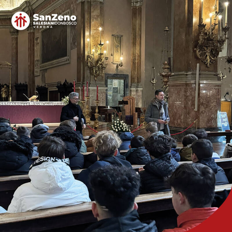 Un gruppo numeroso di persone è seduto sui banchi di una chiesa. Si tratta di studenti e studentesse dell'Istituto Salesiano San Zeno di Verona.